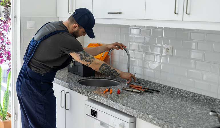 Sacramento plumbing expert repairing bathroom pipe